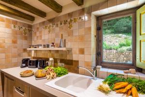 eine Küche mit Spüle und Fenster in der Unterkunft Logement d'exception dans le Château de Lacypierre in Saint-Crépin-et-Carlucet