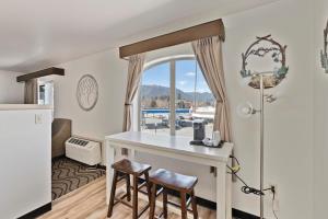 a kitchen with a table and two stools at Cedar Street Hotel & Suites in Sandpoint