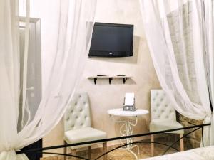 a bedroom with two chairs and a tv on the wall at Antico Casale Fabrizi in Velletri