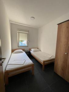 a room with two beds and a window at Apartmani Milenko in Bela Crkva
