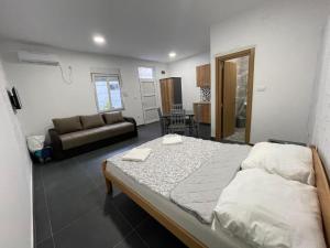 a bedroom with a large bed and a couch at Apartmani Milenko in Bela Crkva