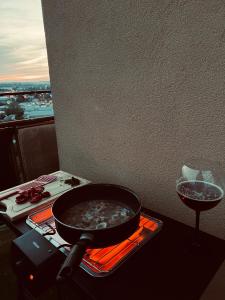 a pot of food on a stove with a wine glass at Penthouse na 12 poschodí s terasou a výhľadom na celé mesto in Nitra