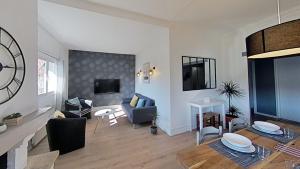 a living room with a large clock on the wall at Maison idéale pour visiter Paris Versailles - Chambres privées Paris-Saclay in Bures-sur-Yvette