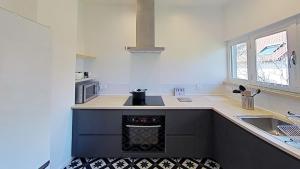 une cuisine avec un comptoir noir et blanc dans l'établissement Maison idéale pour visiter Paris Versailles - Chambres privées Paris-Saclay, à Bures-sur-Yvette