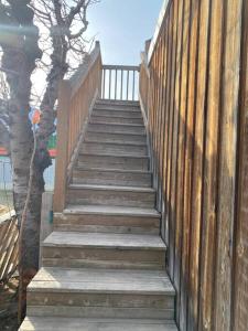a wooden staircase with a wooden fence and a tree at Luisa's guest suite in Keremeos