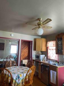 a kitchen with a table and a ceiling fan at Luisa's guest suite in Keremeos