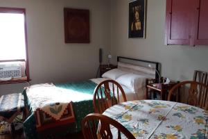 a room with two beds and a table and chairs at Luisa's guest suite in Keremeos