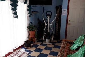 a room with a checkered floor with an exercise bike at Luisa's guest suite in Keremeos