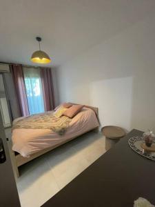 Un dormitorio con una cama y una mesa. en Maison 3chambres ,climatisée en Nimes