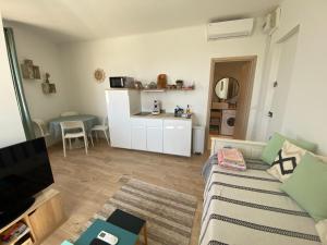 a living room with a couch and a table at Studio le Monroe les pieds dans l'eau 10 m de la mer in La Seyne-sur-Mer