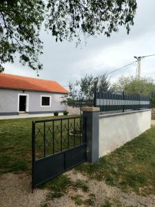 a black gate in front of a white house at Holiday Home Nena in Drniš