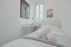 een witte slaapkamer met een bed met een handdoek erop bij Piccardi in Trieste
