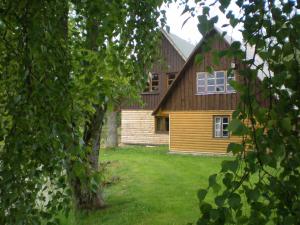 a house seen through the leaves of trees at Jāmaņi in Vigale