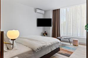 a bedroom with a bed and a flat screen tv at One88 Apartments in Bucharest