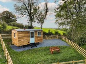 a tiny house in the middle of a yard at Berllan Y Bugail Shepherds Hut in Llanwrda