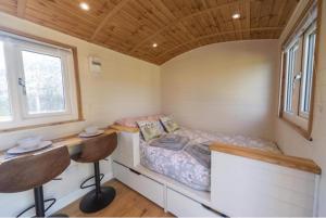 a small bedroom with a bed and a desk at Berllan Y Bugail Shepherds Hut in Llanwrda