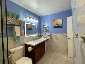 a bathroom with blue walls and a toilet and a sink at Amazing waikiki Beach condo 2Bed2Bath+free Parking in Honolulu