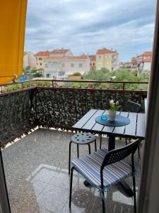 a table and chairs on a balcony with a view at Apartman Valor in Rovinj