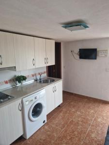 een keuken met een wasmachine en een wastafel bij Apartamento Malaga Aeropuerto in Cártama