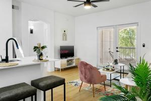 a white living room with a table and a chair at TWO Cozysuites with Pool Jacuzzi in Glendale 10&03 in Glendale +37 photos