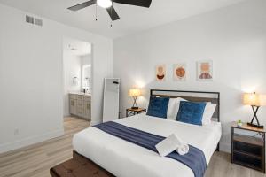 a bedroom with a large white bed with blue pillows at CozySuites at TPC Scottsdale with parking and pool in Scottsdale