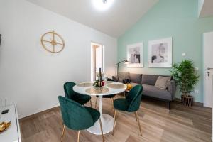 ein Wohnzimmer mit einem Tisch, Stühlen und einem Sofa in der Unterkunft Apartment Kate with FREE PARKING in Dubrovnik