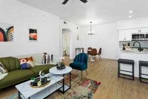a living room with a green couch and a kitchen at CozySuites Glendale by the stadium with pool 01 in Glendale