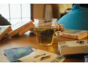 un vaso de cerveza sentado en una mesa con libros en The Ryokan Tokyo Yugawara - Vacation STAY 21489v en Miyakami