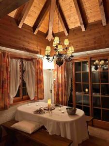 ein Esszimmer mit einem Tisch und einem Kronleuchter in der Unterkunft Romantische Oase mit Kamin in Unterseen