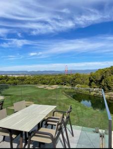 a table and chairs on a patio with a view of a golf course at La Pineda playa in La Pineda