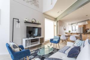 インディアナポリスにあるUpscale 3BR Penthouse by CozySuitesのソファとテレビのあるリビングルーム