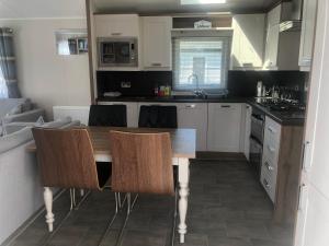 una piccola cucina con tavolo e sedie in legno di A spacious and beautifully presented 2 bedroom holiday home a Bembridge