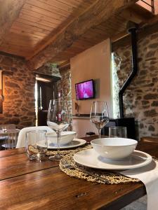 - une table en bois avec des assiettes et des verres à vin dans l'établissement El Secreto De Arlanza, à Arlanza