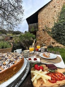una mesa cubierta con un pastel y platos de comida en El Secreto De Arlanza, en Arlanza