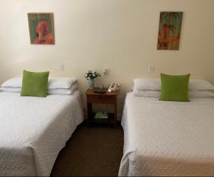 - 2 lits avec des oreillers verts dans une chambre dans l'établissement Hotel Ponce de Leon, à Miami