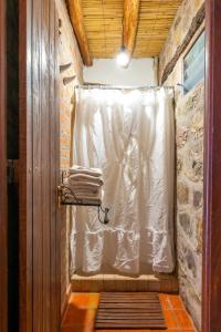 a shower with a white shower curtain in a room at Cabañas Malka in Tilcara