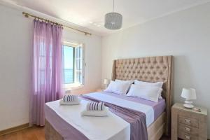 a bedroom with two beds with purple curtains and a window at Montesan Luxury Apartment in Sveti Stefan