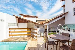 a balcony with a table and chairs and a swimming pool at Pousada Dona Clô in Rio de Janeiro