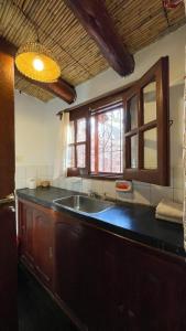 uma cozinha com um lavatório e uma janela em Cabañas Malka em Tilcara