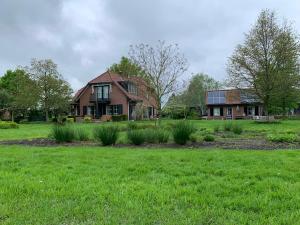 a house in a field with a grass yard at Lovely warm Country home in Breukeleveen