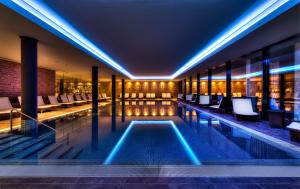 a pool in a hotel with chairs and tables at Wellnesshotel Golfpanorama in Lipperswil