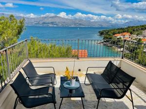 a balcony with chairs and a table and a view of the water at Villa SARA in Postira