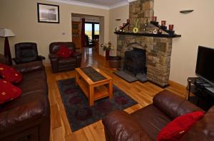 sala de estar con sofá y chimenea en Cottage 147 - Renvyle, en Renvyle