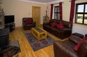 a living room with leather couches and a tv at Cottage 147 - Renvyle in Renvyle