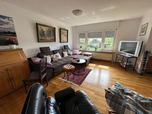a living room with a couch and a tv at Ferienappartment mit Homeoffice, 2 Schlafzimmer mit Einzelbetten in Weil am Rhein