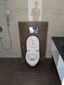ein Badezimmer mit einem weißen WC und einer Dusche in der Unterkunft Moksha Infinity Valley in Kotagiri