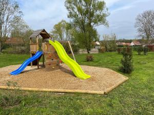 a playground with a slide and a play structure at DOMAINE DES GALINACES ROULOTTE LA ROUSSETTE 2-4P in Marigny-lès-Reullée