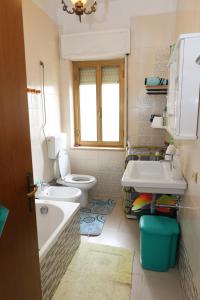 a bathroom with a toilet and a sink and a tub at Le Gardenie b&b in Marina di Schiavonea