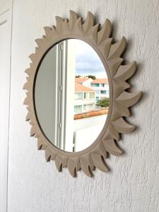 un miroir circulaire sur un mur avec une fenêtre dans l'établissement BUBBLE GOM'Z, à Saint-Hilaire-de-Riez