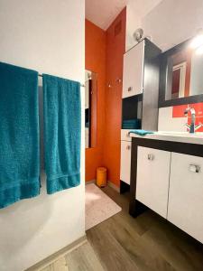eine kleine Küche mit blauen Handtüchern und einem Waschbecken in der Unterkunft BUBBLE GOM'Z in Saint-Hilaire-de-Riez